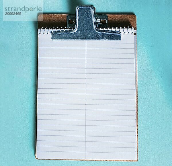 Top view of notepad on isolated background. Note book on clipboard on color background