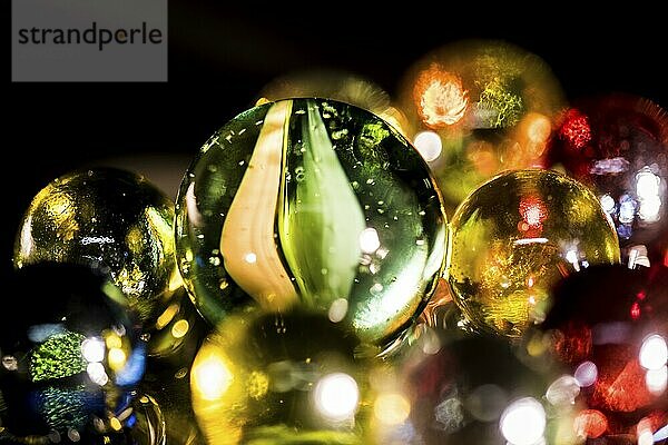 Colourful glass balls mirrored on a black background