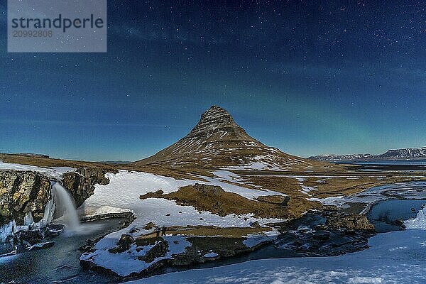 Long exposure of Kirkjufell snowy mountain and its beautiful waterfall in Icelandic winter