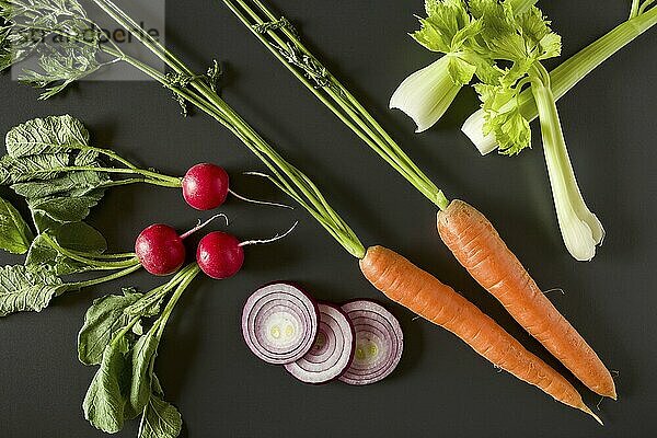 Fresh raw vegetables over a dark background seen from above