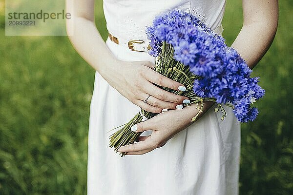 Girl holds bouquet of wild flowers on the wedding