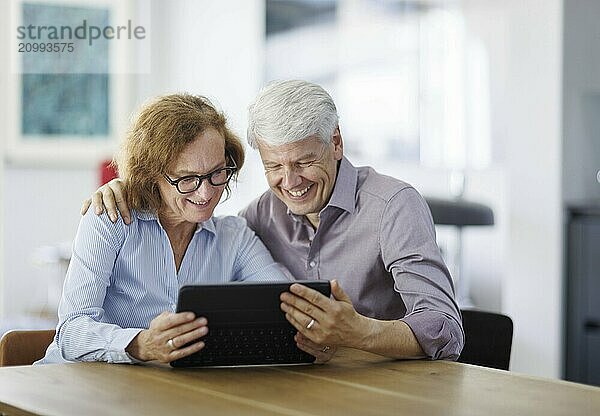 Symbolic photo. A woman and a man sit together at a table with a tablet and talk. Berlin  13.08.2024