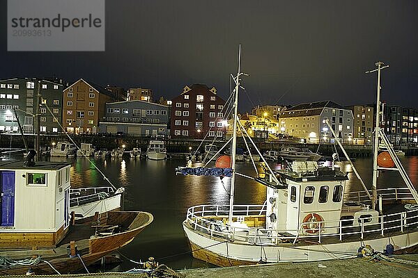 Nocturnal harbour view with fishing boats and illuminated buildings  reflecting in the calm water  Trondheim  Nidarelva  Tröndelag  Norway  Europe