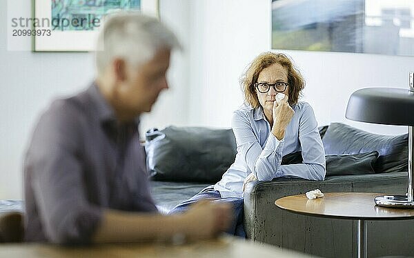 Symbolic photo on the subject of problems in a partnership. An older woman and an older man sitting at home. Berlin  13.08.2024