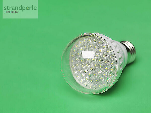 LED light bulb. Energy saving light source. Isolated on green background