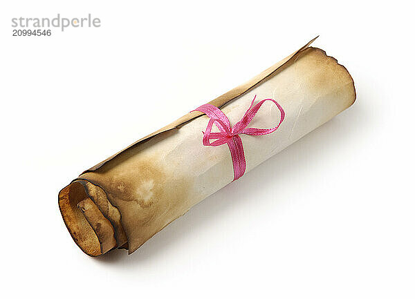 Roll of yellowish burnt vintage parchment tied with a red ribbon Isolated over white background