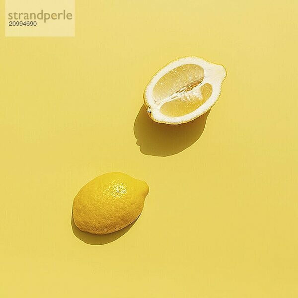 Two halved cuts of lemon with shadow on yellow background. Healthy eating  travel or vacation concept