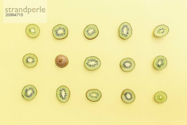 Slices and cuts of kiwi fruit on yellow background. Healthy eating  travel or vacation concept