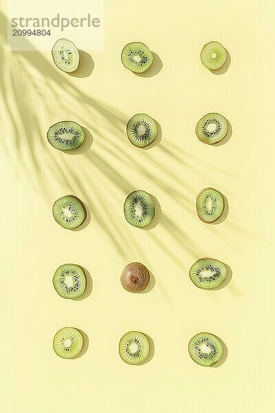 Slices and cuts of kiwi fruit pattern on yellow background. Healthy eating  travel or vacation concept