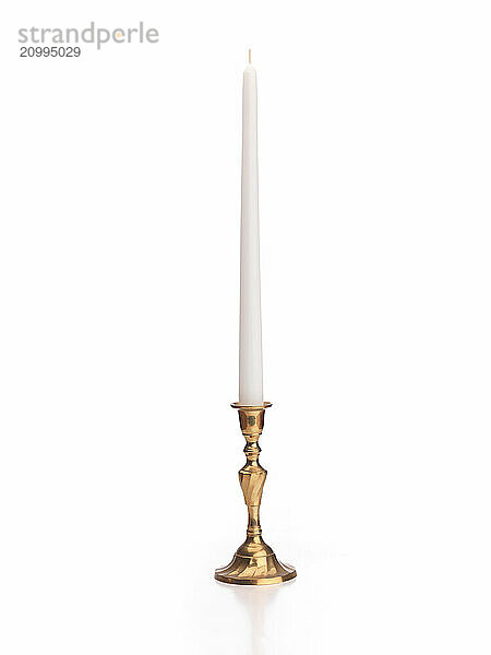 Candle in brass candlestick isolated on white background