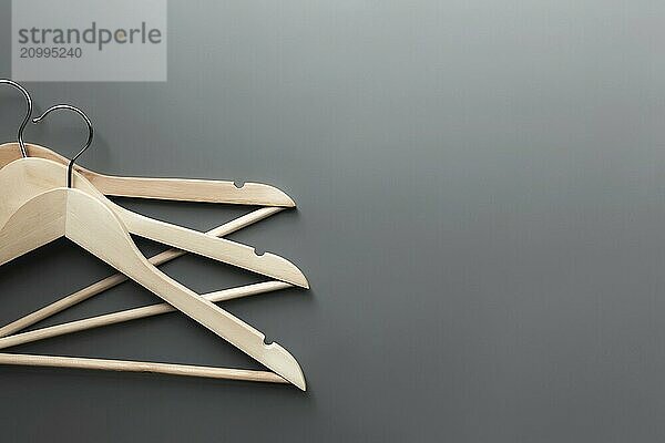 Black Friday or clothing industry concept on gray background flat lay with straight folded wooden clothes hangers