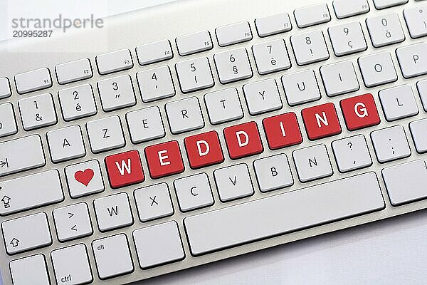 WEDDING writing on white keyboard with a heart sketch