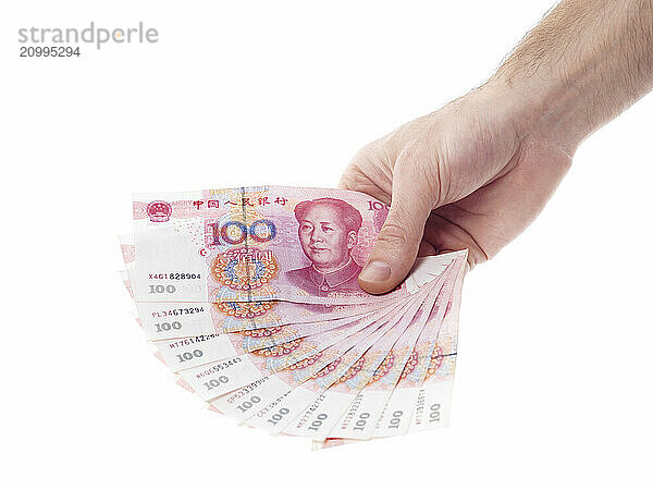 Male hand holding Chinese Yuan 100 bills Renminbi money currency isolated on white background