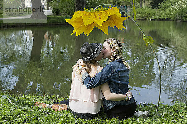 A couple kissing under a sunflower