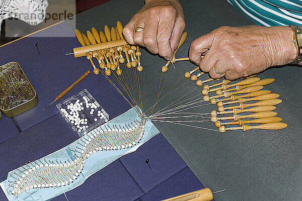 Elderly woman making lace according to old handicraft technique