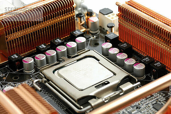 Computer motherboard with a CPU in a socket and copper heatsinks