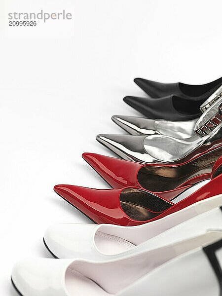 Four pairs of fashionable high heel stiletto shoes on white background