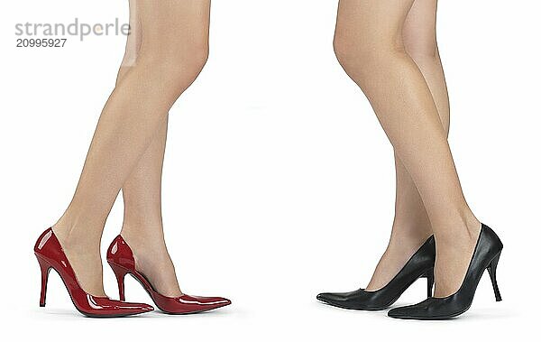 Two woman legs in high heel shoes isolated on white background