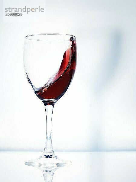 Red wine in a glass artistic dynamic photo isolated on bright white background