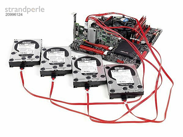 Hard drives connected to computer motherboard with a RAID controller isolated on white background