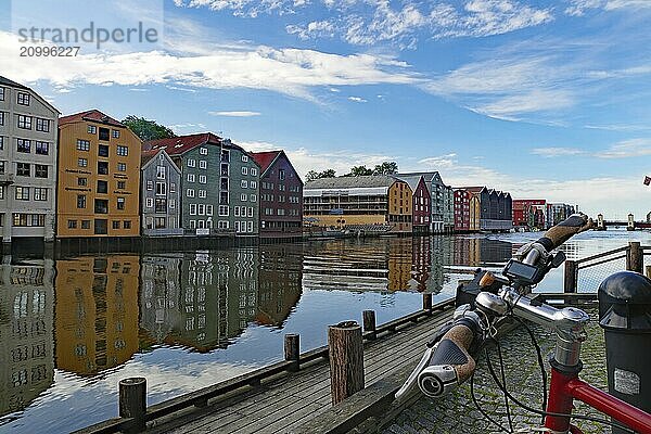 Wooden building on the riverbank with reflections in the water and a bicycle in the foreground  Nidarelva  Trondheim  Tröndelag  Norway  Europe