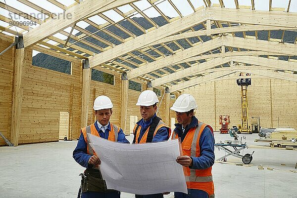 Three builders discuss the plan for a major construction job