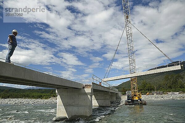 Builders construct a concrete bridge over a small river in Westland  New Zealand  Oceania