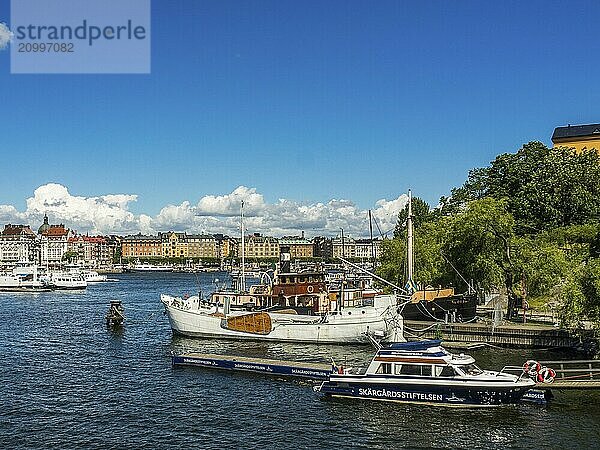 A harbour with several boats and ships in front of a cityscape under a blue sky  stockholm  baltic sea  sweden  scandinavia