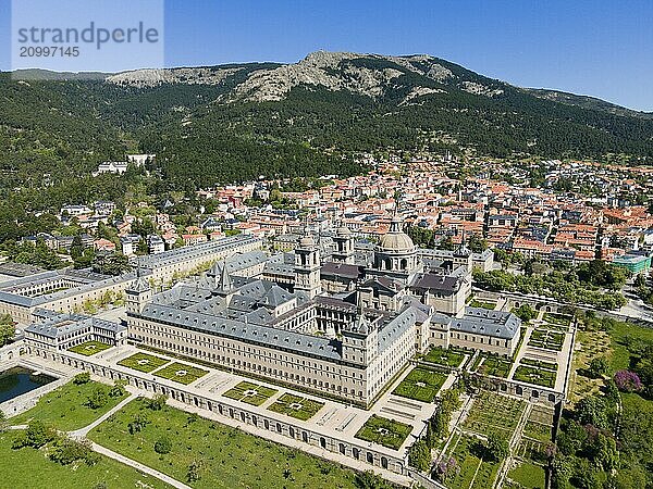 Historic monastery and neighbouring town  surrounded by green landscape and mountains  seen from the air  aerial view  Real Sitio de San Lorenzo de El Escorial  Royal Seat of Saint Lawrence of El Escorial  palace and monastery complex  San Lorenzo de El Escorial  Madrid  Spain  UNESCO World Heritage Site  Europe