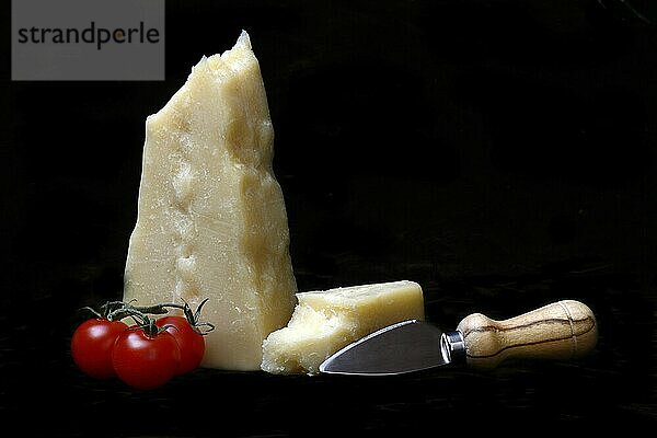 A piece of Parmesan cheese with cheese knife  tomatoes  Italy  Europe