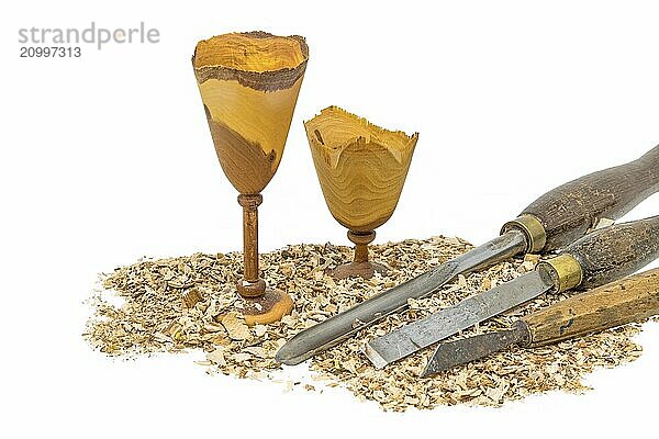 Hand-turned wooden goblets decorated with sawdust and tools painted on white