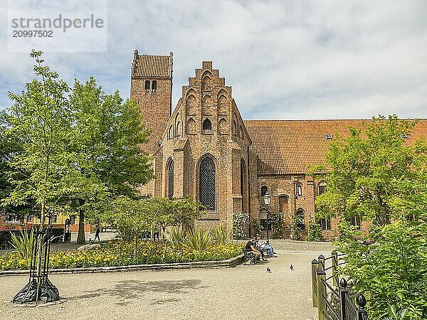 Historic brick church with blooming flower bed and surrounded by trees  ystad  sweden  baltic sea  scandinavia