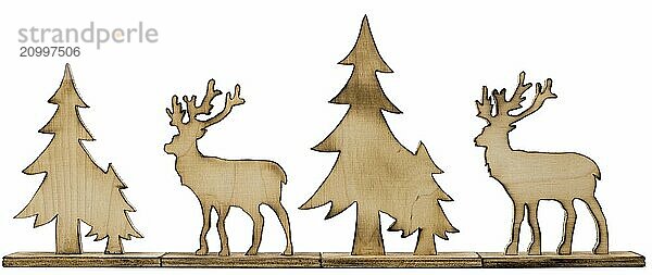 Deer figure sawn out of wood with dark edges and wooden fir trees cut out on white