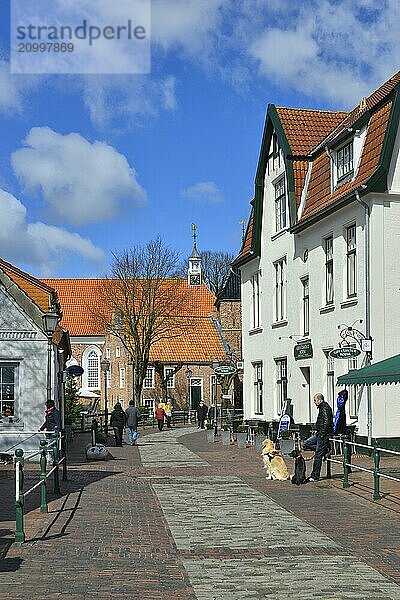 Greetsiel townscape in the Mühlenstrasse. In the background the Protestant-Lutheran St Mary's Church  Krummhörn  East Frisia  Lower Saxony  Germany  Europe