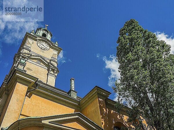 Church tower in front of blue sky and green tree  stockholm  baltic sea  sweden  scandinavia