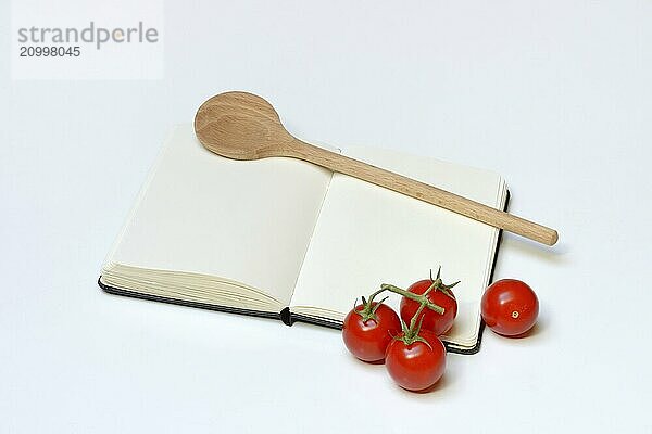 Notebook for recipes  cooking spoons  pasta and tomatoes