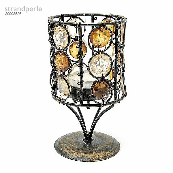 Antique metal candle holder with glass facets against a white background