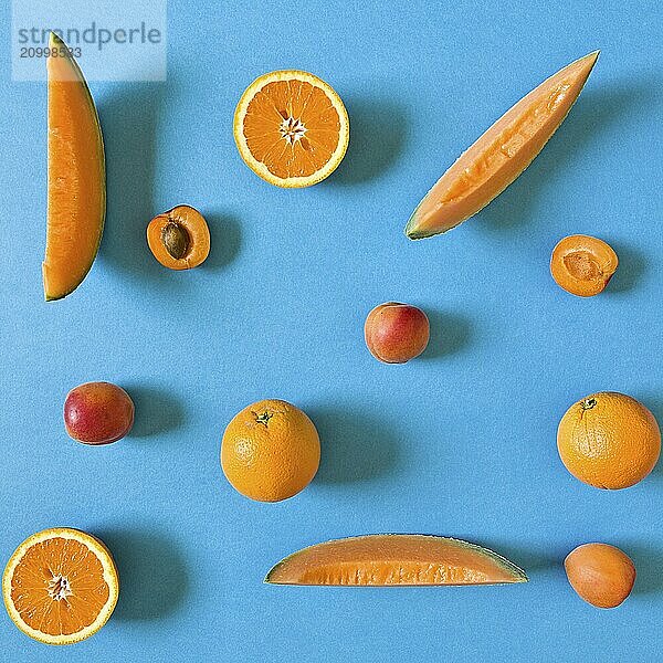 Fresh orange toned fruits over a blue background