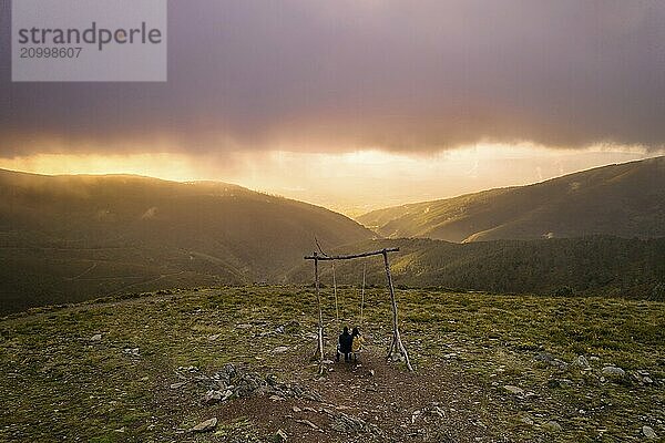 Romantic couple drone aerial view swinging on a Swing baloico in Lousa mountain social distancing  Portugal at sunset