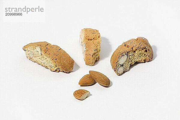 Three almond cantuccini and three almonds on white background