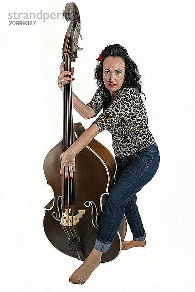 Middle-aged woman with a double bass on a white background in the studio