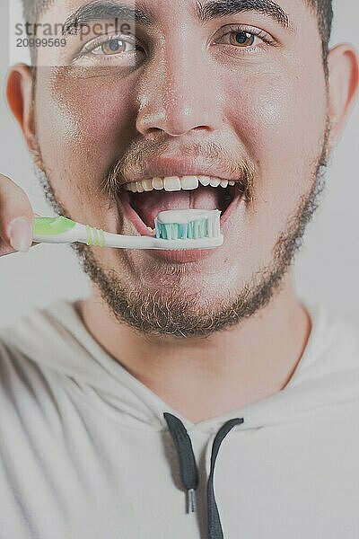 Smiling man brushing teeth isolated. Health and tooth brushing concept