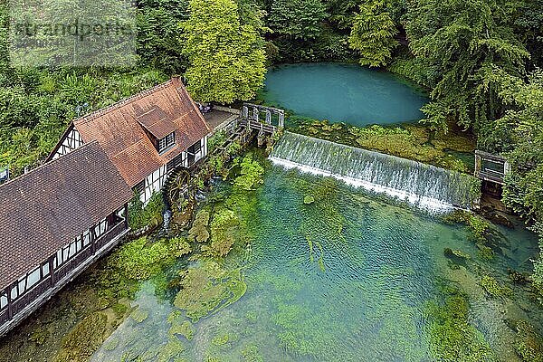 Blautopf Blaubeuren with industrial monument Hammerschmiede  source of the little river Blau in a landscape with forest. Karst spring  geotope and geopoint of the UNESCO Swabian Alb Geopark  tourist attraction. The popular excursion destination is now being thoroughly renovated and will therefore be closed to visitors until the end of 2028. Drone photo. Blaubeuren  Baden-Württemberg  Germany  Europe