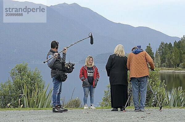 MOANA  NEW ZEALAND  APRIL 23  2018: A film crew interviews a young woman at the edge of Lake Brunner for a documentary story