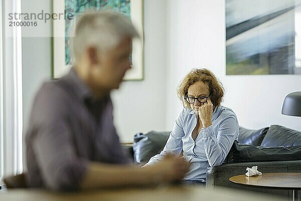 Symbolic photo on the subject of problems in a partnership. An older woman and an older man sitting at home. Berlin  13.08.2024