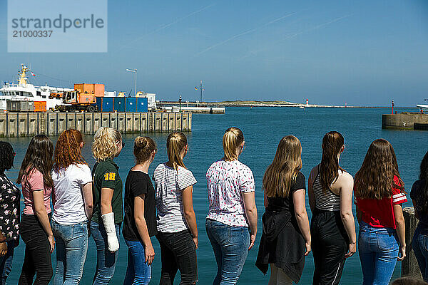 Group of girls standing on the jetty looking out to sea  Helgoland  Schleswig-Holstein  Germany  Europe