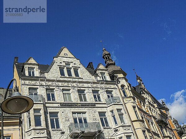 Several residential buildings with balconies and architectural details stand under a clear blue sky  stockholm  baltic sea  sweden  scandinavia