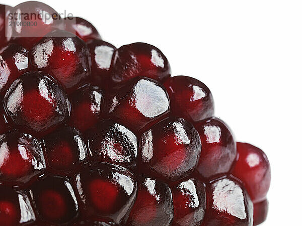 Closeup of red pomegranate arils isolated on white background