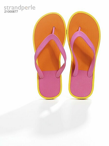 Pair of orange flip flops isolated on white background