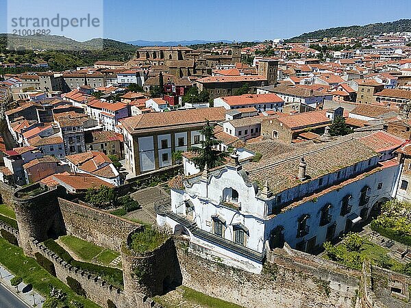 White historic building next to a wall  surrounded by red tiled roofs and trees  aerial view  city wall  Plasencia  Cáceres  Caceres  Extremadura  Spain  Europe